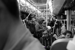 People riding in a crowded subway car.