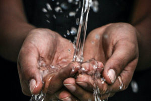 Water running through cupped hands.
