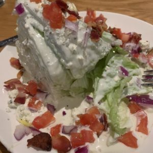 The Wedge Salad, with chopped tomatoes, bacon, blue cheese chunks and blue cheese dressing.